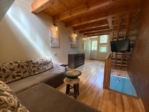 a living room with a couch and a flat screen tv at Bungalow Smiltele in Nida