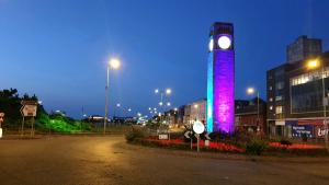 a tall clock tower with a purple light on it at Gabriel Guesthouse in Rhyl