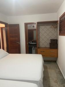 a bedroom with a bed and a bathroom with a sink at Paraíso Flecheiras in Trairi +23 photos