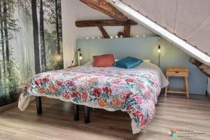 1 dormitorio con 1 cama con colcha de flores en Lî Gurni en Houffalize