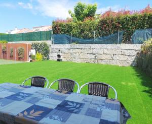 una mesa con cuatro sillas en un patio en CHALET A SOLO 5 MIN DE OURENSE CIUDAD con jardín y barbacoa, en Ourense