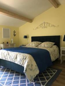 um quarto com uma cama grande e um edredão azul em Tess Cottage em Brie-sous-Mortagne