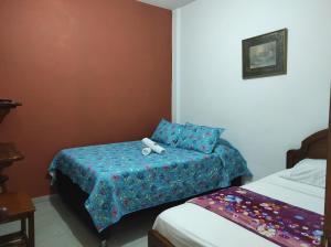 Cette chambre comprend deux lits et un lit avec un oreiller. dans l'établissement Hotel Barajas, à Jardín
