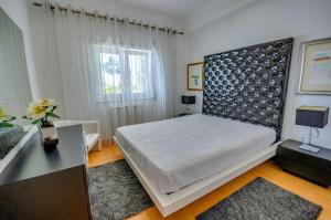 a bedroom with a large bed and a window at Apartamentos 7 saias in Nazaré