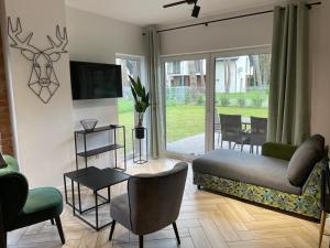 a living room with a couch and a tv at Zielone Rozewie Park in Rozewie