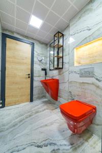 a bathroom with a red toilet and a sink at Aria Riva Apart Hotel in Alanya