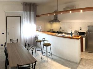 a kitchen with a counter and a table and chairs at Skyandsand Alghero in Alghero