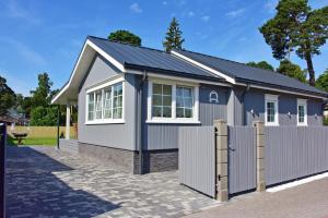a blue and white house with a fence at Villa Elena in Ventspils
