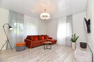 a living room with a red couch and some windows at Villa Elena in Ventspils