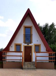 uma pequena casa com dois bancos em frente em DOMKI NAD ŁOWISKIEM em Giżycko