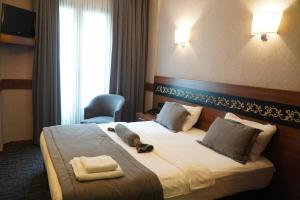 Un pat sau paturi într-o cameră la Bern Hotel