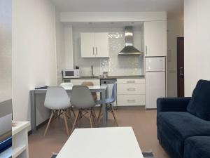 kuchnia i salon ze stołem i krzesłami w obiekcie Portosín -Suites w mieście Portosin