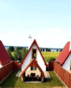 uma pequena casa com um telhado vermelho em DOMKI NAD ŁOWISKIEM em Giżycko