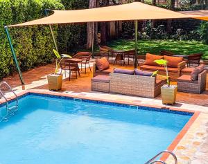 a swimming pool with chairs and an umbrella at Margarita House in Nairobi