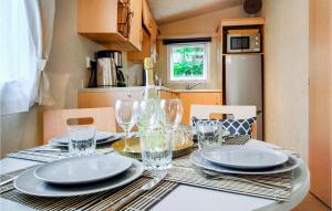 a dining room table with plates and glasses on it at 2 Bedroom Lovely Home In Heinkenszand in Heinkensand