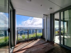 a room with glass doors and a balcony with a view at Union Green Apt w Stunning Views - Free Parking in Auckland