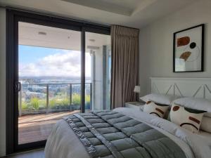 a bedroom with a large bed and a large window at Union Green Apt w Stunning Views - Free Parking in Auckland