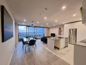 a kitchen and living room with a table and chairs at Union Green Apt w Stunning Views - Free Parking in Auckland