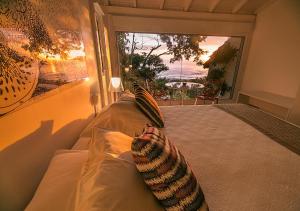 a bedroom with a bed with a view of the ocean at Pousada Morada dos Bougainvilles in Praia do Rosa