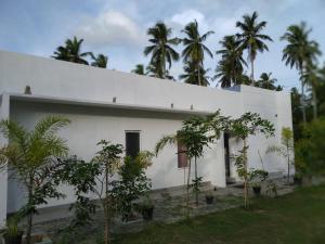 un edificio blanco con árboles delante de él en ULPATHA NATURE RESORT, en Kurunegala