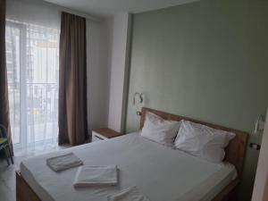 ママイア・ノルドにあるVila Bordei Verdeのベッドルーム1室(白いシーツ付きのベッド1台、窓付)