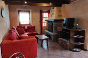 salon z czerwoną kanapą i kominkiem w obiekcie Casa vacanze Monica ' s house w mieście Saint-Pierre