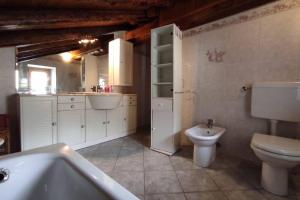 łazienka z toaletą, umywalką i wanną w obiekcie Casa vacanze Monica ' s house w mieście Saint-Pierre