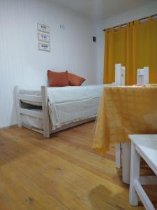 ein weißes Bett in einem Zimmer mit gelbem Vorhang in der Unterkunft TURISMO RURAL La Amorosa Club de Campo in Colón