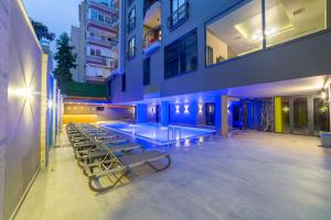 a pool in the middle of a building with chairs at Aria Riva Apart Hotel in Alanya