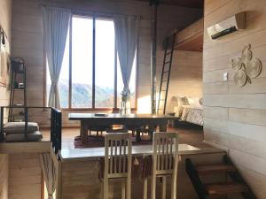 Un comedor con mesa y sillas y una ventana. en La melliza, en San Carlos de Bariloche