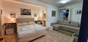 a bedroom with a bed and a couch at Apartman Šego in Vela Luka