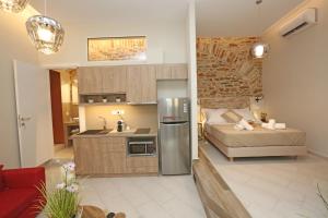 une cuisine et une chambre avec un lit dans une pièce dans l'établissement One Suite Syros, à Ermoúpoli