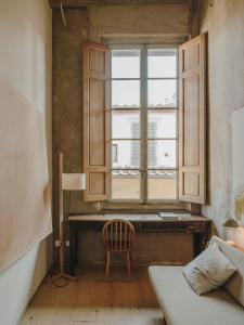 a bedroom with a desk and a window and a chair at Numeroventi Design Residency in Florence