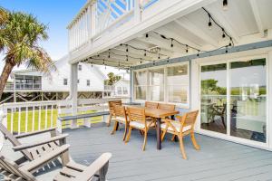 a porch with a wooden table and chairs at Belle Mare in Folly Beach