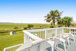 a white deck with chairs and a view of the ocean at Belle Mare in Folly Beach