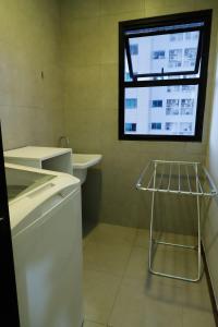 La salle de bains est pourvue d'un lavabo et d'une fenêtre. dans l'établissement Sofisticado Loft Mobiliado no Coração do Umarizal, à Belém