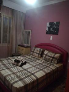 um quarto com uma cama com uma cabeceira vermelha em Sitiahome em Sitia
