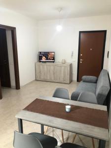 a living room with a table and a couch at Casa vacanze al parco in Giba