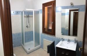 a bathroom with a shower and a sink at Casa vacanze al parco in Giba +5 photos