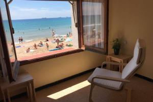 Cette chambre dispose d'une fenêtre offrant une vue sur la plage. dans l'établissement El Faro Apartaments Platja Llarga-Les Salines-TGN, à Tarragone