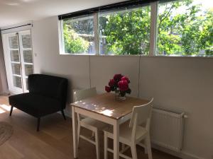 mesa y sillas en una habitación con ventana en De Haarlemse Logeerkamer, en Haarlem