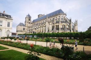 un grand bâtiment avec un jardin en face dans l'établissement Aux 3 Maillets, à Bourges