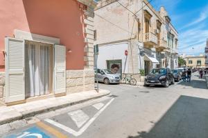 a street with cars parked on the side of a building at La Vite Bianca in Polignano a Mare