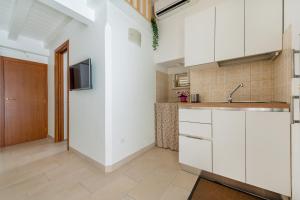 a kitchen with white cabinets and a sink and a door at La Vite Bianca in Polignano a Mare