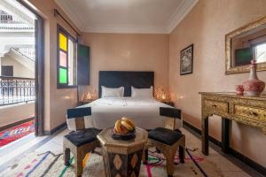 a bedroom with a bed and a table and a desk at Riad Salman in Marrakech