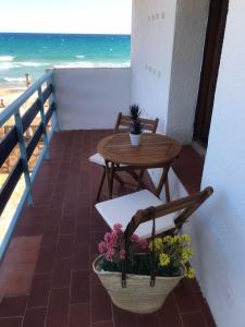una mesa y sillas en un balcón con vistas a la playa en El Faro Apartaments Platja Llarga-Les Salines-TGN, en Tarragona