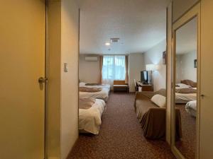 a hotel room with four beds and a mirror at Hotel Ginsui - Vacation STAY 58206v in Kanayama