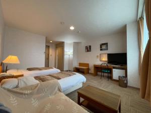 um quarto de hotel com duas camas e uma televisão em Hotel Ginsui - Vacation STAY 58202v em Kanayama