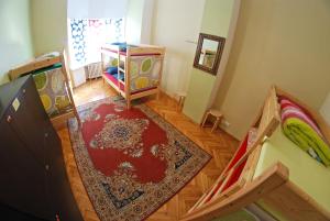 - un salon avec un lit et un tapis dans l'établissement The Monk's Bunk Kaunas, à Kaunas