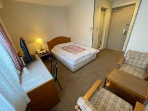 Kanayama的住宿－Hotel Ginsui - Vacation STAY 58198v，小房间设有一张床、一张桌子和椅子